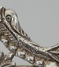 Antieke zilveren beugel- of rokhaak met dolfijnen